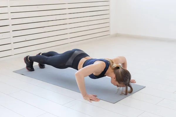 Gente, deporte y fitness concepto - joven deportista hermosa haciendo flexiones —  Fotos de Stock