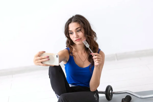 Stile di vita sano, concetto di persone - giovane donna che mangia un'insalata dopo lo sport e fa selfie — Foto Stock