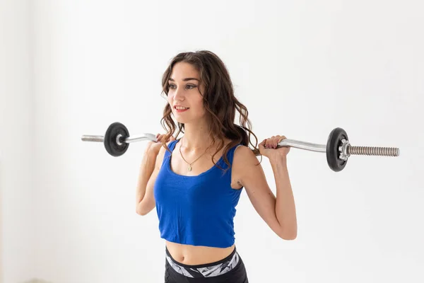 Fitness, deporte y el concepto de la gente - sonriente mujer deportiva con barra haciendo sentadilla dividida o embestida — Foto de Stock