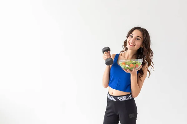 Sport, stile di vita sano, concetto di gente - giovane donna bruna con insalata e un manubrio. Sta sorridendo e godendo lo stile di vita sano — Foto Stock