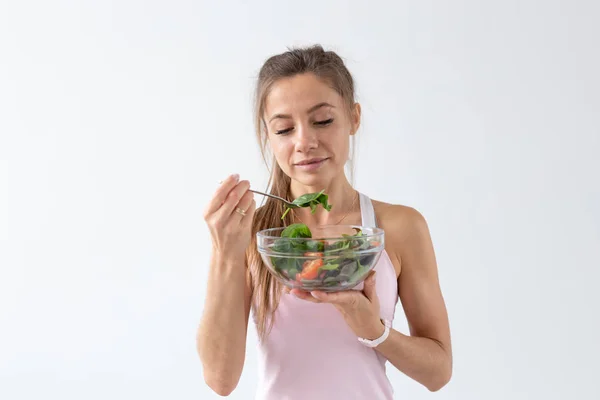 Lidé, jídlo a dieta koncept - portrét ženy, jíst zdravé jídlo nad bílým pozadím — Stock fotografie