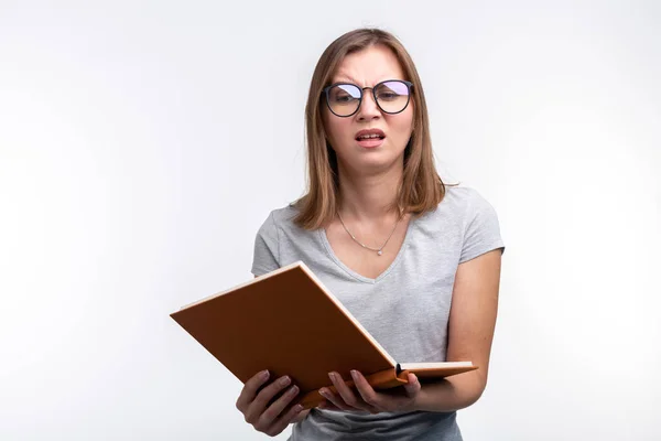 Estudio, educación, concepto de la gente - estudiante mujer está cansada de aprender clases, ella está en camisa gris, de pie con libro abierto — Foto de Stock