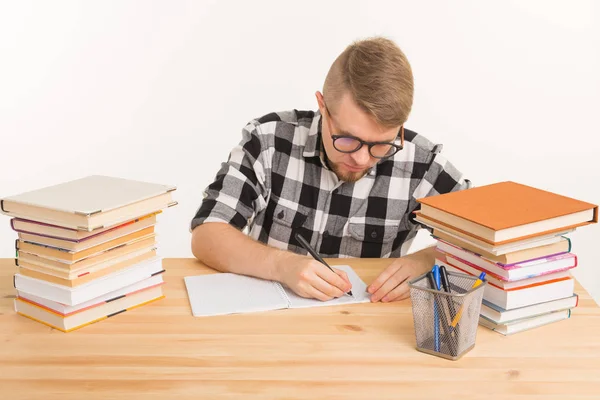 Concepto de personas y educación: el tipo se sienta a la mesa y toma notas en un cuaderno — Foto de Stock