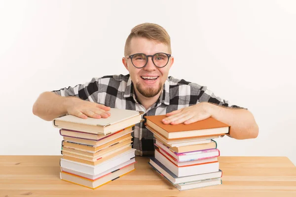 Persone, conoscenza ed educazione - uomo sorridente seduto al tavolo di legno con libri — Foto Stock