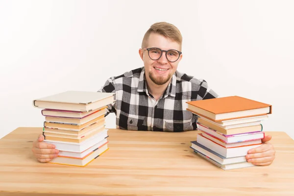 Pessoas, conhecimento e conceito de educação - Estudante engraçado feliz vestido com camisa xadrez sentado na mesa de madeira com livros — Fotografia de Stock