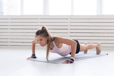 Sağlıklı yaşam, spor, insanlar kavramı - genç bir kadın fitness spor salonu ya da ev yapıyor. O spor elbiseli baskı yapıyor