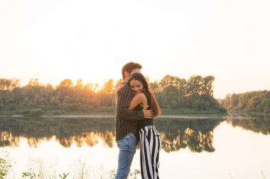 Romantik ve insanlar kavramı - birlikte nehir ya da göl sarılma ve yaz vaktinizi genç Çift
