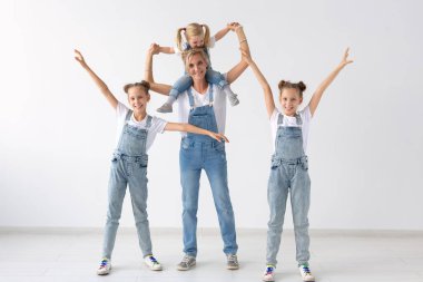 kişi, Aile ve çocuk kavramı - beyaz arka plan üzerinde onun İkiz kızları ve kız bebek ile eğlenmek bir güzel annesi portresi