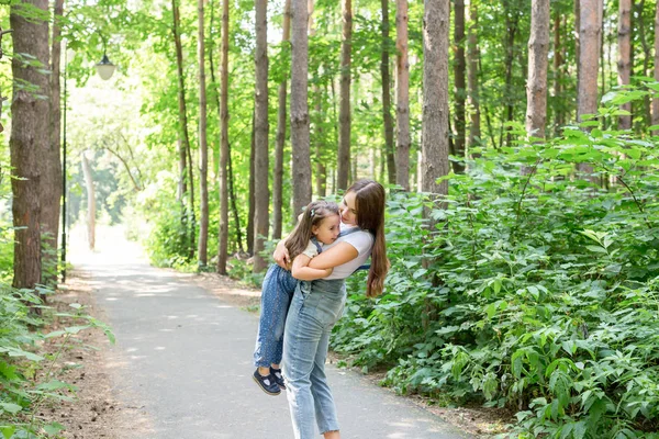 Familien- und Naturkonzept - junge Frau hält kleine Tochter — Stockfoto