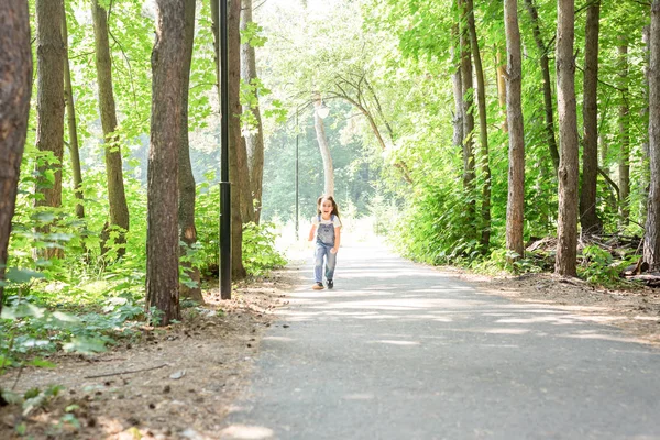 Kinderen, jeugd, mensen concept - een meisje gelukkig kind-wandelen in de zomer park — Stockfoto