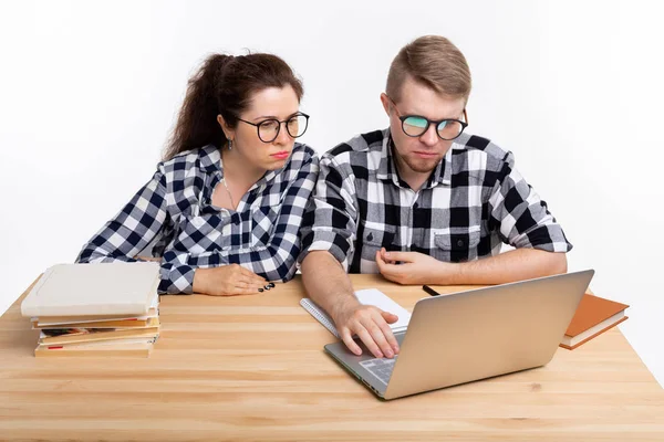 Ανθρώπους και εκπαίδευση έννοια - δύο προβληματισμένοι φοιτητές σε καρό πουκάμισα που κάθεται στο τραπέζι — Φωτογραφία Αρχείου