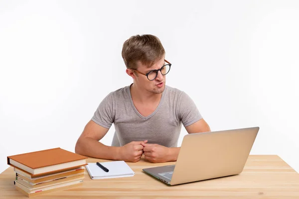 El estudio, la educación y el concepto de emociones - estudiante masculino haciendo ejercicios en el ordenador portátil. Está perplejo. — Foto de Stock