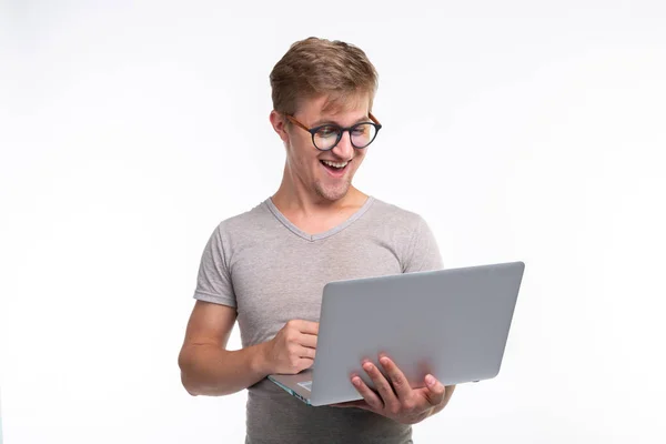 Las emociones, la educación y el concepto de la gente - un joven guapo mirando en el ordenador portátil y riendo — Foto de Stock