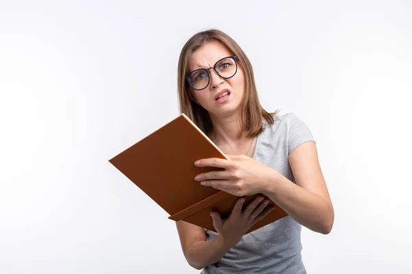 Badania, edukacja, koncepcja ludzi - kobiet student jest zmęczony nauki klas, ona jest w szarej koszuli, stojąc z otwartej książki — Zdjęcie stockowe