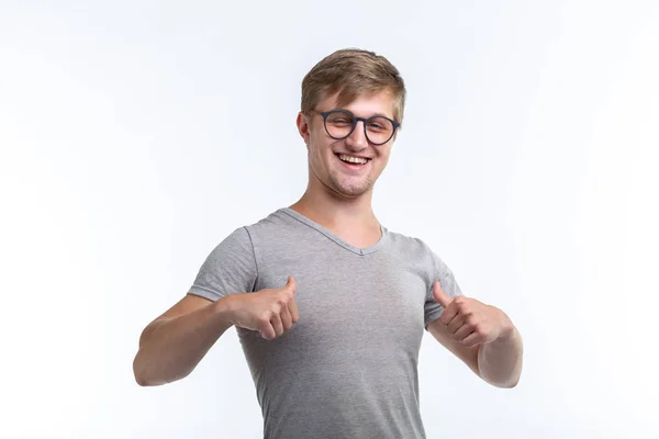 Youth, student and people concept - young man looks like a nerd show us thumbs up over the white background — Stock Photo, Image