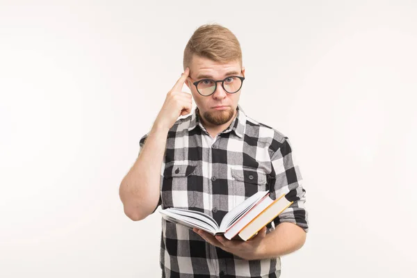 Examen, conocimiento y concepto de educación: el estudiante inteligente señala la cabeza o el cerebro sosteniendo libros en sus manos sobre un fondo blanco — Foto de Stock