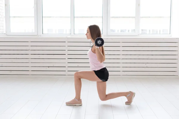 Fitness, deporte, concepto de personas - mujer joven en traje deportivo, guantes está en cuclillas con bar — Foto de Stock