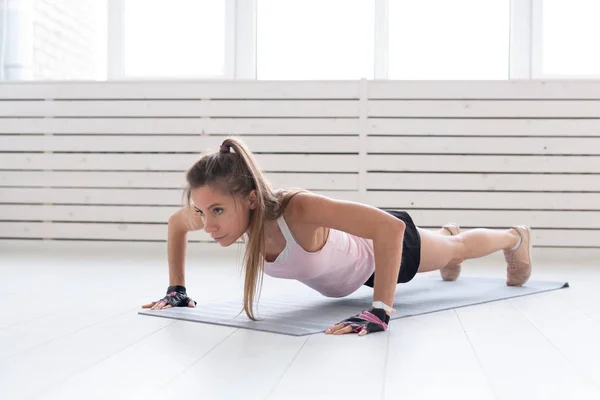 Estilo de vida saudável, esporte, conceito de pessoas uma jovem está fazendo fitness no ginásio ou em casa. Ela está pressionando no terno esporte — Fotografia de Stock