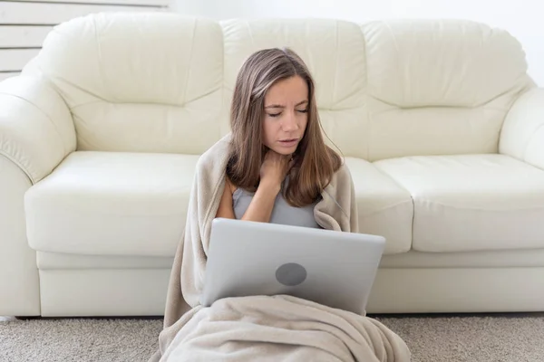 Kobieta o ból gardła, siedząc na podłodze z laptopa — Zdjęcie stockowe