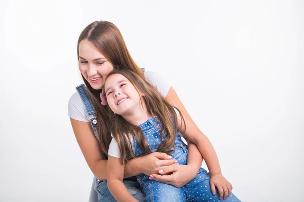 Conceito de pais, família e filhos - Retrato de uma mãe e sua menina se divertem e sorriem sobre fundo branco — Fotografia de Stock