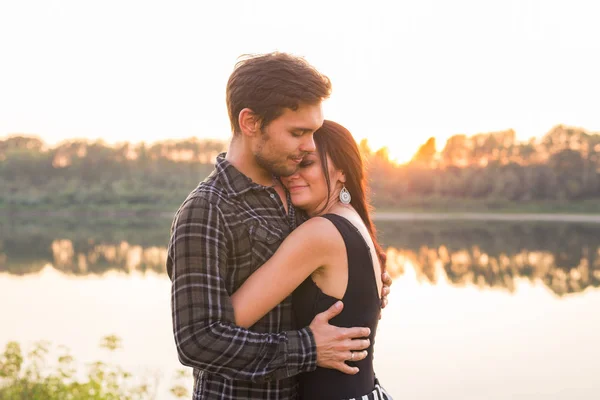 Relazione, amore e concetto di natura - Donna attraente e bell'uomo che abbraccia e bacia sullo sfondo dell'acqua — Foto Stock