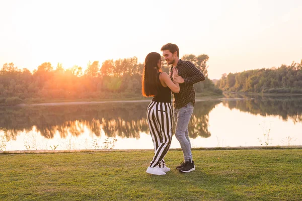Concepto de baile romántico, social y de personas - pareja joven bailando un tango o bachata cerca del lago — Foto de Stock