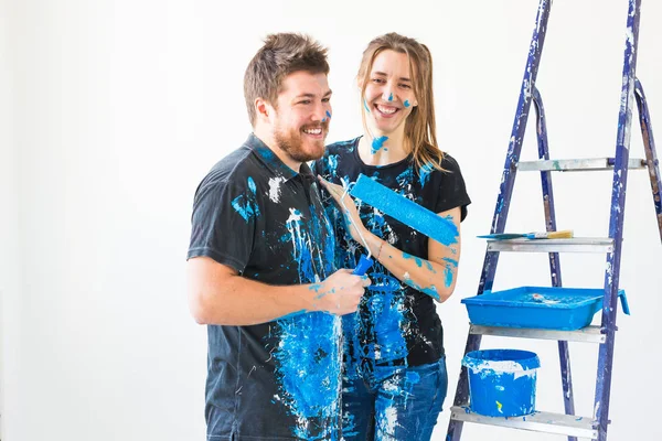 Reparação, renovação e conceito de pessoas - casal vai pintar a parede, eles estão preparando a cor e escovas — Fotografia de Stock
