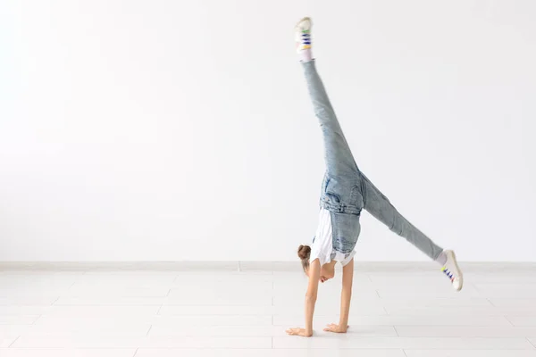 Concepto de la gente, el deporte y los niños - niña bonita haciendo gimnasia sobre fondo blanco —  Fotos de Stock