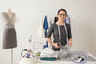 Terzi, moda tasarımcısı ve terzi kavramı - genç kadın tasarımcı güzel hafif kumaş keser
