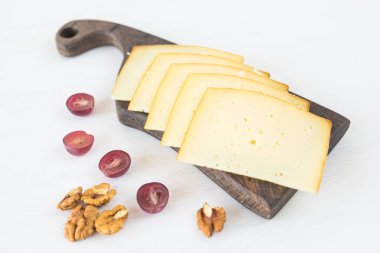 Taze ürünler. Üzüm ve fındık ile peynir rustik masanın üzerine dilimlenmiş.