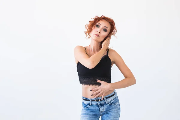 Gente y concepto de moda - Mujer atractiva en un top negro posando sobre fondo blanco con espacio de copia — Foto de Stock