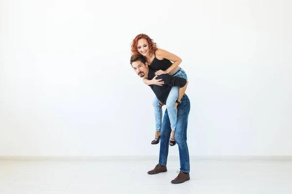 People and love concept - Beautiful pretty woman sitting at men back and embracing him on white background with copy space — стоковое фото