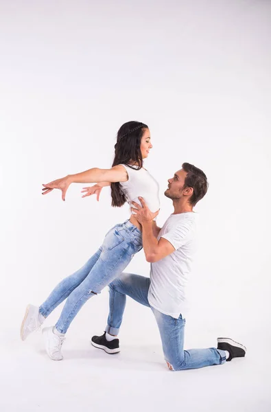 Young couple dancing social dance bachata, merengue, salsa, kizomba. Two elegance pose on white room. — Stock Photo, Image