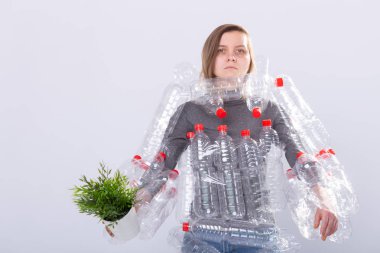 Çevre Koruma, insanlar ve geri dönüştürülebilir plastik kavram - beyaz arka plan üzerinde yeşil bitki tutan plastik şişe ler gibi elbise ile çevre felaketi ile ilgili yorgun kadın
