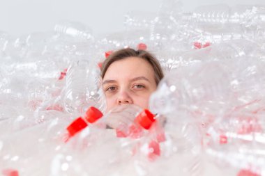 Plastik kirlilik sorunu ve çevre koruma. Plastik şişe yığını içinde zayıf yorgun kadın. Earth konsepti kaydedin. Doğanın temizliği.