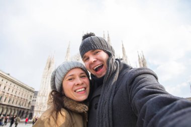 Milano'daki Duomo meydanında kendi portresini çeken çift. Kış seyahati, İtalya ve ilişki konsepti