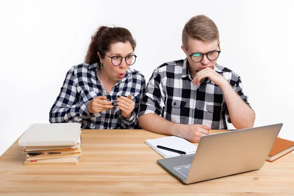 Istruzione, studenti, concetto di persone - un paio di adolescenti con gli occhiali hanno paura di qualcosa durante la ricerca nel computer portatile — Foto Stock