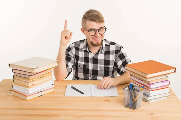 Concepto de personas, conocimiento y educación - Estudiante inteligente sentado a la mesa con libros y cuaderno — Foto de Stock