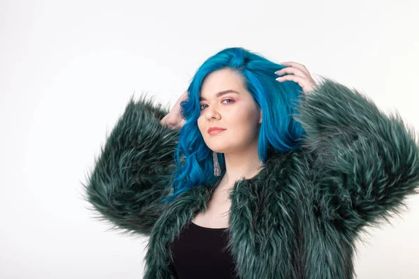 Proteção animal, moda e conceito de cabelo - menina bonita vestida com casaco de pele artificial com cabelo azul em pé sobre fundo branco — Fotografia de Stock