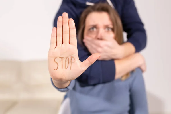 La gente, la violencia doméstica y el concepto de abuso - Mujer muestra dejar de abusar de signo. Hombre cubre su boca con su mano — Foto de Stock
