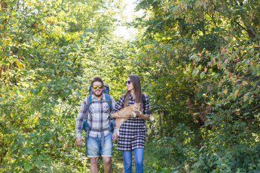 Seyahat, Macera, zam, turizm ve doğa kavramı - turist çift ormanda yürüyüş kedi ile
