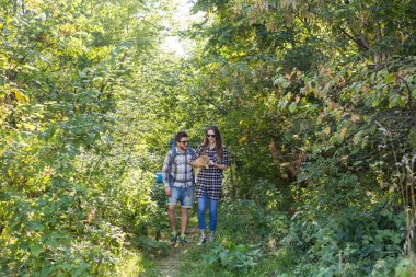 Seyahat, Macera, zam, turizm ve doğa kavramı - turist çift ormanda yürüyüş kedi ile
