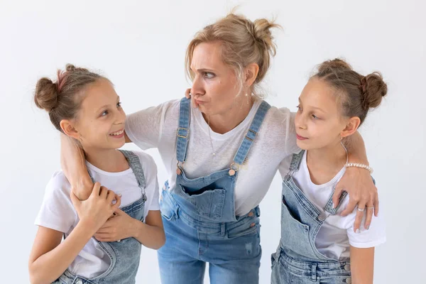 Concepto de personas, familia e hijos - hermanas gemelas con su madre sobre fondo blanco — Foto de Stock