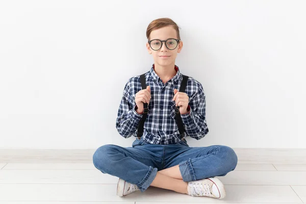 Teenager, Kinder und Modekonzept - modischer Junge auf dem Boden vor weißem Hintergrund — Stockfoto