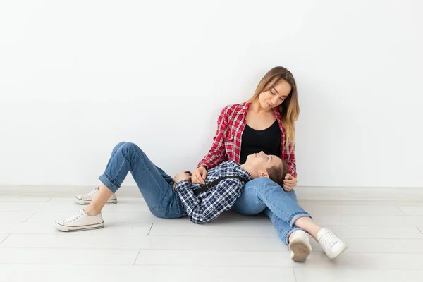 Mothers day, children and family concept - cute teen boy with his young mother at home — Stock Photo, Image