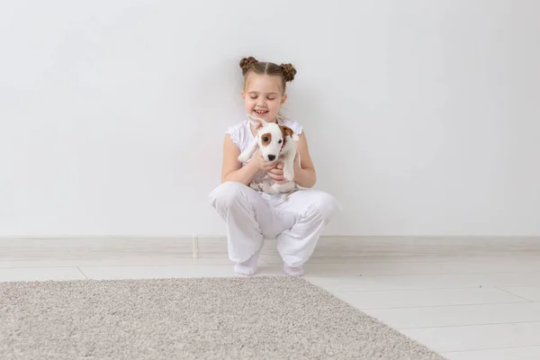 Perros, mascotas y concepto animal - Niña sentada con el cachorro Jack Russell Terrier — Foto de Stock