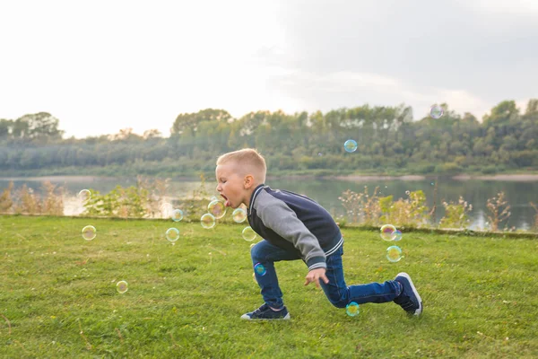 Infância, conceito de pessoas - menino brincando com bolhas de sabão — Fotografia de Stock