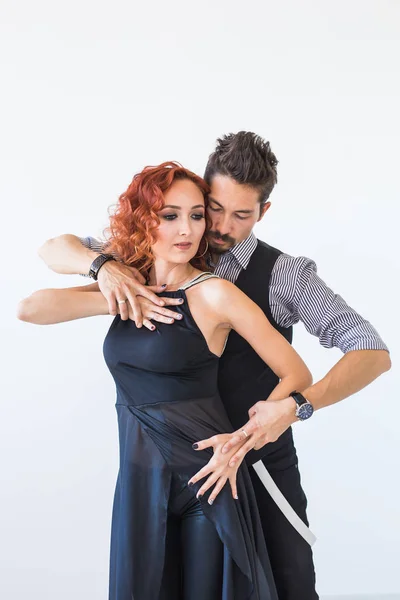 Dança social, bachata, kizomba, zouk, conceito de tango - Homem abraça mulher enquanto dança sobre fundo branco no estúdio — Fotografia de Stock