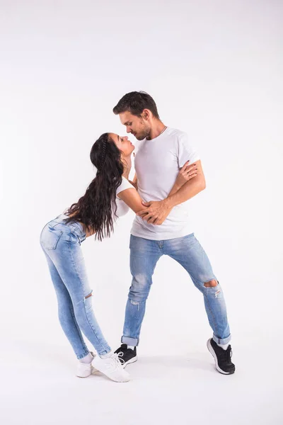 Jeune couple dansant danse sociale bachata, merengue, salsa, kizomba. Deux pose d'élégance sur chambre blanche . — Photo