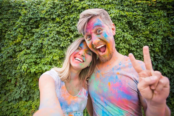 Фестиваль Холи, люди концепции - молодая пара делает селфи в красочной грязной одежде — стоковое фото